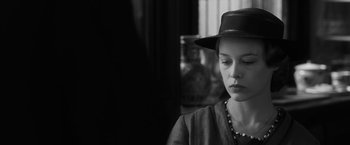 Movie still from “Frantz” (2016), directed by François Ozon – A woman wearing a black hat and a necklace; Close Up shot, Over the shoulder angle