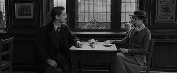 Movie still from “Frantz” (2016), directed by François Ozon – Two men sitting at a table in front of each other; Medium shot, Over the shoulder angle