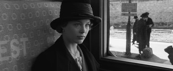 Movie still from “Frantz” (2016), directed by François Ozon – A young woman wearing a hat looking out of a window; Close Up shot, Over the shoulder angle