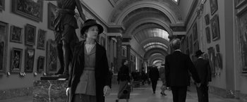 Movie still from “Frantz” (2016), directed by François Ozon – A black and white photo of people walking in a hallway; Wide shot, Low angle
