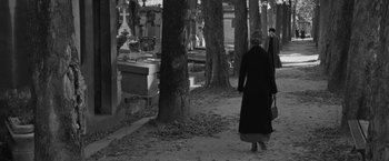 Movie still from “Frantz” (2016), directed by François Ozon – Two people walking through a cemetery near a tree; Wide shot, Over the shoulder angle