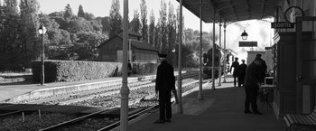 Movie still from “Frantz” (2016), directed by François Ozon – A man standing on a train platform waiting for a train to arrive; Extreme Wide shot, High angle