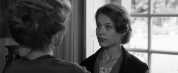 Movie still from “Frantz” (2016), directed by François Ozon – A woman looking into a mirror while talking to another woman; Close Up shot, Over the shoulder angle
