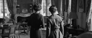 Movie still from “Frantz” (2016), directed by François Ozon – Two young women standing next to each other in front of a window; Medium shot, Over the shoulder angle