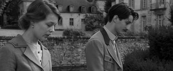 Movie still from “Frantz” (2016), directed by François Ozon – A man and a woman standing next to each other in front of a stone wall; Medium shot, Over the shoulder angle