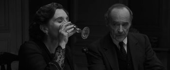Movie still from “Frantz” (2016), directed by François Ozon – An older man and a woman drinking from glasses; Close Up shot, Over the shoulder angle