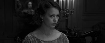 Movie still from “Frantz” (2016), directed by François Ozon – A woman with a necklace looking to her left; Close Up shot, Over the shoulder angle