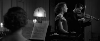 Movie still from “Frantz” (2016), directed by François Ozon – A woman is standing in front of an open book; Medium shot, Over the shoulder angle