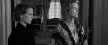 Movie still from “Frantz” (2016), directed by François Ozon – Two women standing next to each other in a living room; Medium shot, Over the shoulder angle