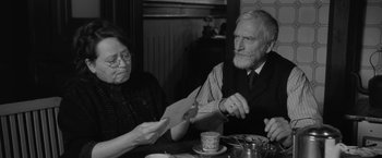 Movie still from “Frantz” (2016), directed by François Ozon – An older man and woman sitting at a dinner table; Medium shot, Over the shoulder angle