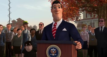 Movie still from “Free Birds” (2013), directed by Jimmy Hayward – A man in a suit and tie standing in front of a crowd; Medium shot, Low angle