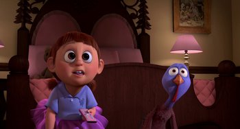 Movie still from “Free Birds” (2013), directed by Jimmy Hayward – A girl and a bird are sitting next to each other in a living room; Medium shot, High angle