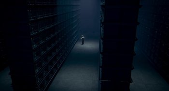 Movie still from “Free Birds” (2013), directed by Jimmy Hayward – A man standing in a dark room surrounded by stacks of books; Extreme Wide shot, High angle