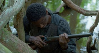 Movie still from “Free State of Jones” (2016), directed by Gary Ross – A man is holding a rifle in his hands; Close Up shot, High angle