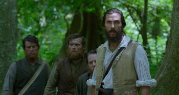 Movie still from “Free State of Jones” (2016), directed by Gary Ross – A group of men standing next to each other in the woods; Medium shot, Over the shoulder angle