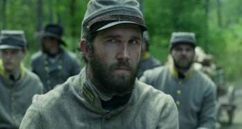 Movie still from “Free State of Jones” (2016), directed by Gary Ross – A man in a civil war uniform with a beard; Close Up shot, Over the shoulder angle