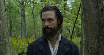 Movie still from “Free State of Jones” (2016), directed by Gary Ross – A man with a long beard is standing in the woods; Close Up shot, Low angle