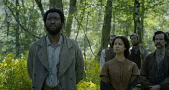 Movie still from “Free State of Jones” (2016), directed by Gary Ross – A man and a woman standing next to each other in the woods; Medium shot, Low angle