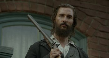 Movie still from “Free State of Jones” (2016), directed by Gary Ross – A man with long hair and a beard holding a gun; Close Up shot, Low angle