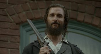 Movie still from “Free State of Jones” (2016), directed by Gary Ross – A man with a beard holding a gun in his hands; Close Up shot, Low angle