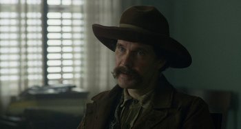 Movie still from “Free State of Jones” (2016), directed by Gary Ross – A man with a mustache wearing a brown hat; Close Up shot, Over the shoulder angle