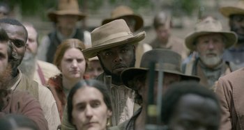 Movie still from “Free State of Jones” (2016), directed by Gary Ross – A group of people standing around each other wearing hats; Close Up shot, Over the shoulder angle