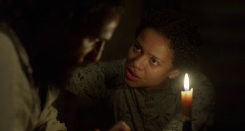Movie still from “Free State of Jones” (2016), directed by Gary Ross – Two people sitting at a table with a lit candle in front of them; Close Up shot, Over the shoulder angle