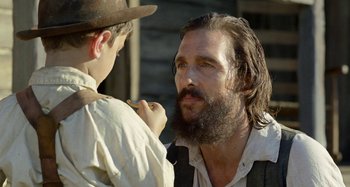 Movie still from “Free State of Jones” (2016), directed by Gary Ross – A man with long hair and a long beard talking to a young boy; Close Up shot, Over the shoulder angle