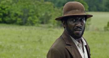 Movie still from “Free State of Jones” (2016), directed by Gary Ross – A man wearing a brown hat and a brown jacket; Close Up shot, Over the shoulder angle