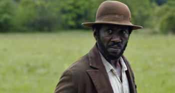 Movie still from “Free State of Jones” (2016), directed by Gary Ross – A man wearing a brown hat and a brown jacket; Close Up shot, Over the shoulder angle