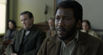 Movie still from “Free State of Jones” (2016), directed by Gary Ross – A man in a brown jacket sitting in front of two other men; Close Up shot, Over the shoulder angle