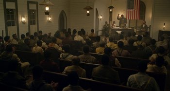 Movie still from “Free State of Jones” (2016), directed by Gary Ross – A group of people sitting in a room; Extreme Wide shot, High angle