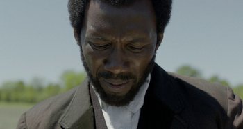 Movie still from “Free State of Jones” (2016), directed by Gary Ross – A person wearing a suit and tie; Close Up shot, Over the shoulder angle