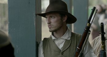 Movie still from “Free State of Jones” (2016), directed by Gary Ross – A man with a hat holding a rifle; Close Up shot, Over the shoulder angle
