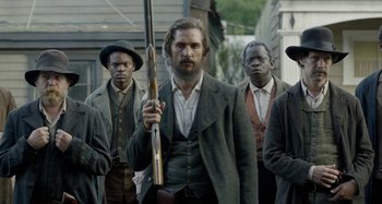 Movie still from “Free State of Jones” (2016), directed by Gary Ross – A group of men standing next to each other holding guns; Medium shot, Over the shoulder angle