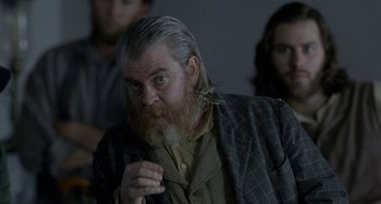 Movie still from “Free State of Jones” (2016), directed by Gary Ross – An old man with a beard and long grey hair; Medium shot, Over the shoulder angle