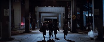 Movie still from “Free Willy” (1993), directed by Simon Wincer – A group of people walking down a street at night; Wide shot, High angle