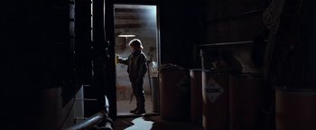Movie still from “Free Willy” (1993), directed by Simon Wincer – A person standing in a room with a light on; Wide shot, Low angle