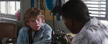 Movie still from “Free Willy” (1993), directed by Simon Wincer – A boy sitting in front of another boy in front of a lamp; Close Up shot, Over the shoulder angle