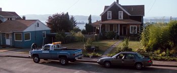 Movie still from “Free Willy” (1993), directed by Simon Wincer – A truck is parked in front of a house; Extreme Wide shot, High angle