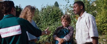 Movie still from “Free Willy” (1993), directed by Simon Wincer – A group of people standing in the grass; Medium shot, Over the shoulder angle