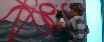 Movie still from “Free Willy” (1993), directed by Simon Wincer – A person with a paint brush on a wall; Medium shot, Over the shoulder angle