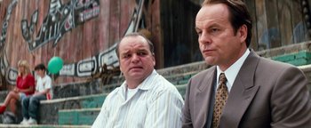 Movie still from “Free Willy” (1993), directed by Simon Wincer – A couple of men standing next to each other on some steps; Close Up shot, Low angle