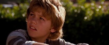 Movie still from “Free Willy” (1993), directed by Simon Wincer – A young boy's face with trees in the background; Close Up shot, Low angle