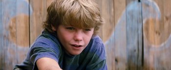 Movie still from “Free Willy” (1993), directed by Simon Wincer – A young boy with blonde hair and blue eyes looking at the camera; Close Up shot, Low angle