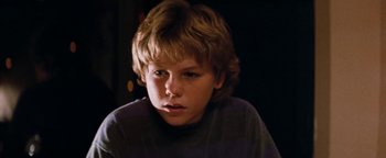 Movie still from “Free Willy” (1993), directed by Simon Wincer – A young boy with blonde hair looking at the camera; Close Up shot, Low angle