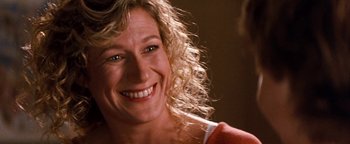 Movie still from “Free Willy” (1993), directed by Simon Wincer – A person with curly blonde hair smiling; Close Up shot, Over the shoulder angle