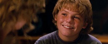 Movie still from “Free Willy” (1993), directed by Simon Wincer – A person smiling for the camera; Close Up shot, Over the shoulder angle