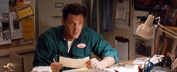 Movie still from “Free Willy” (1993), directed by Simon Wincer – A man sitting at a table writing on a piece of paper; Medium shot, Low angle