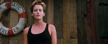Movie still from “Free Willy” (1993), directed by Simon Wincer – A woman in a black tank top standing in front of a wooden wall; Close Up shot, Low angle